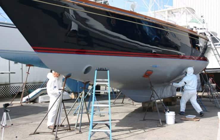 Boat Yard technicians preparing and painting the underwater hull of a hauled vessel