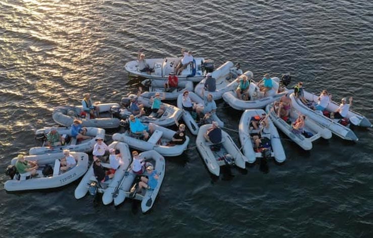 Boaters gathering on the water for a sunset dinghy drift