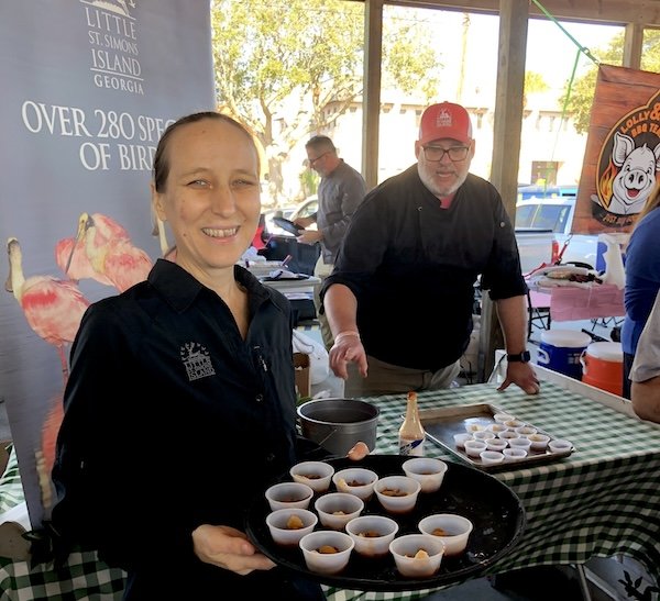 Festival volunteers welcoming guests with samples of Brunswick stew at the Rockin' Stewbilee in Mary Ross Waterfront Park