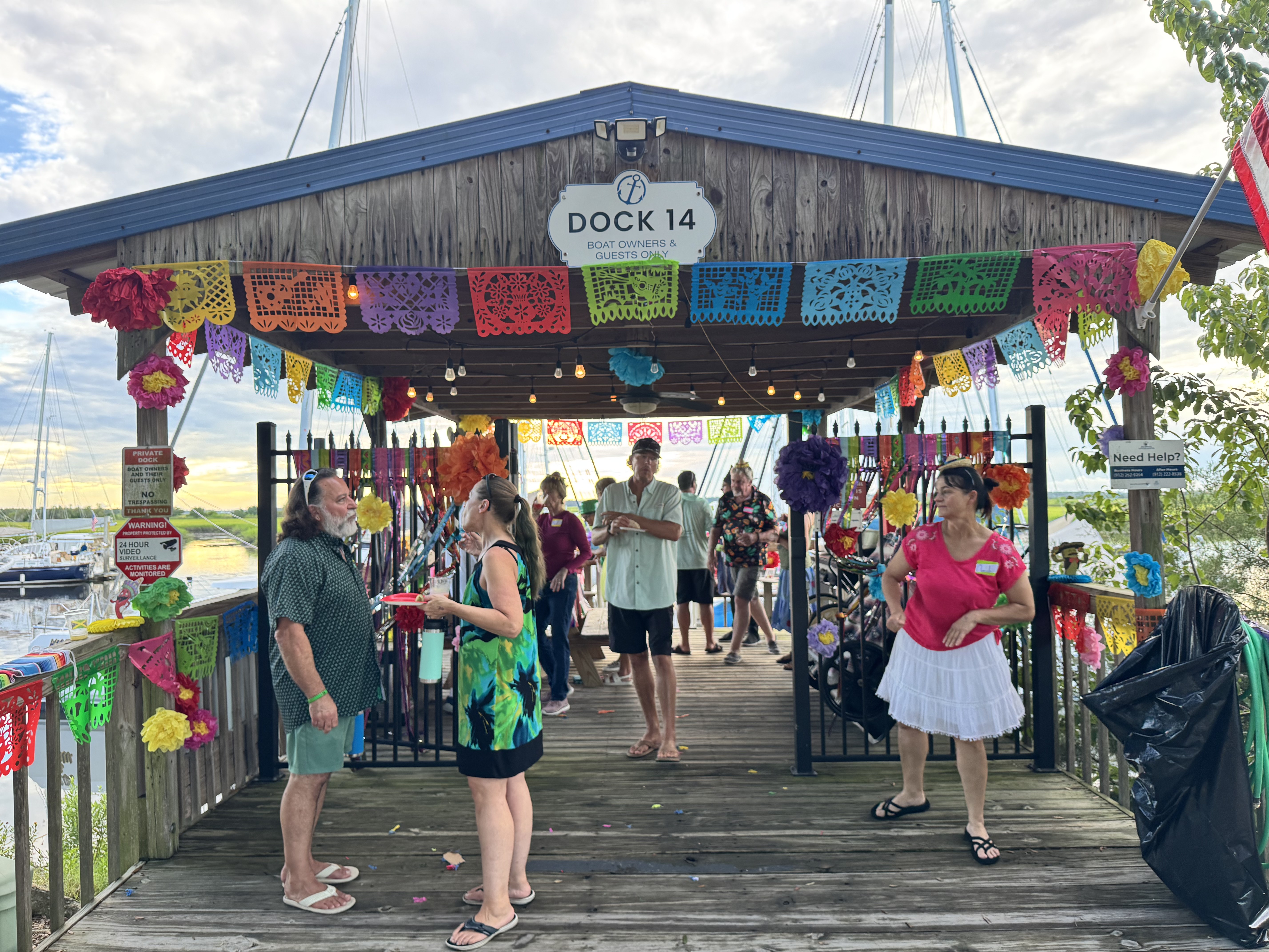 Marina guests exploring Dock 14, decorated as Mexico with colorful papel picado, during Brunswick Landing Marina's Dock Around the World party