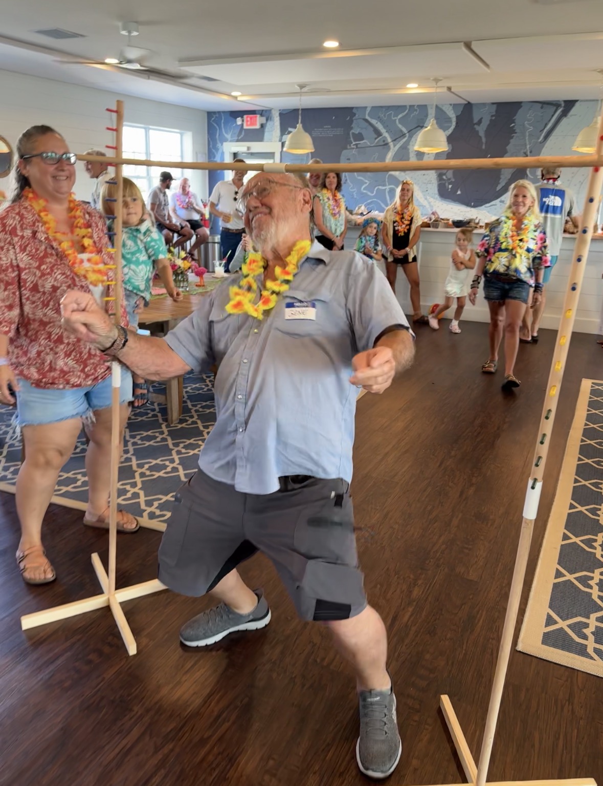Marina guests enjoying a tropical-themed limbo contest inside the Yacht Club