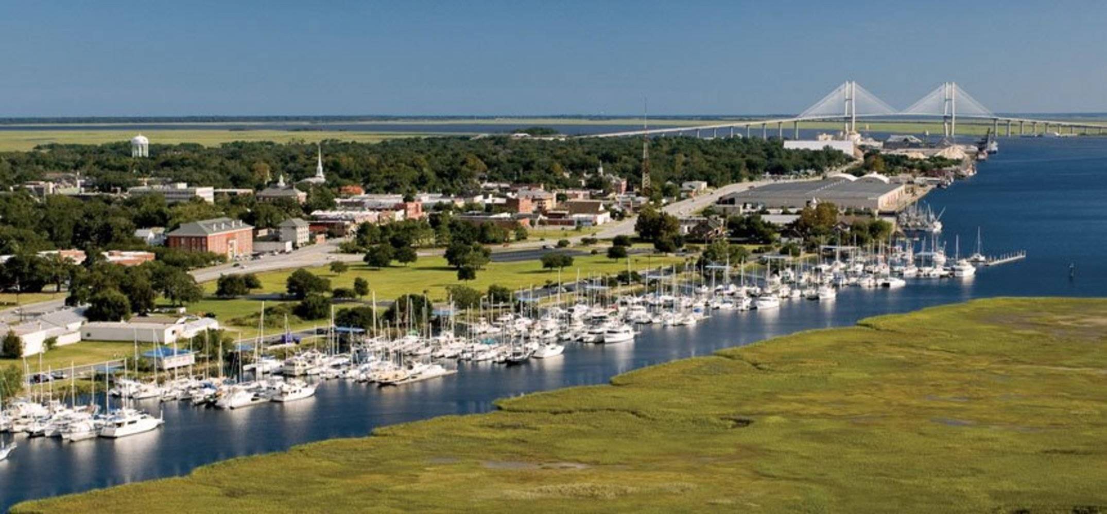 Large yachts and sailboats secured along Brunswick Landing Marina's concrete floating docks